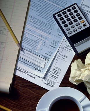 Desk with financial and tax papers, calculator and pencil